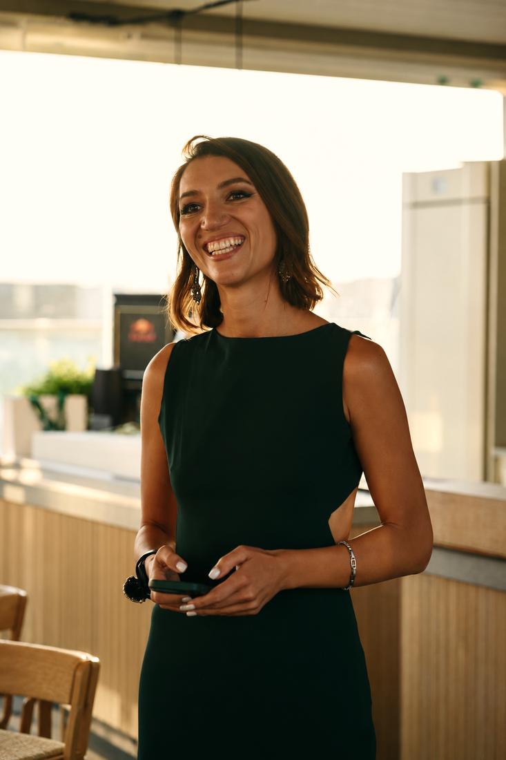 Irina smiling in a black dress at an event