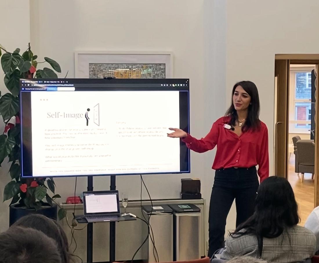 Irina presenting a workshop on self-image in a red shirt