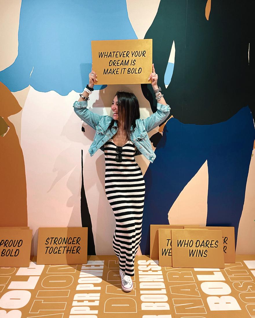 Irina holding up a sign reading 'Whatever your dream is, make it bold'