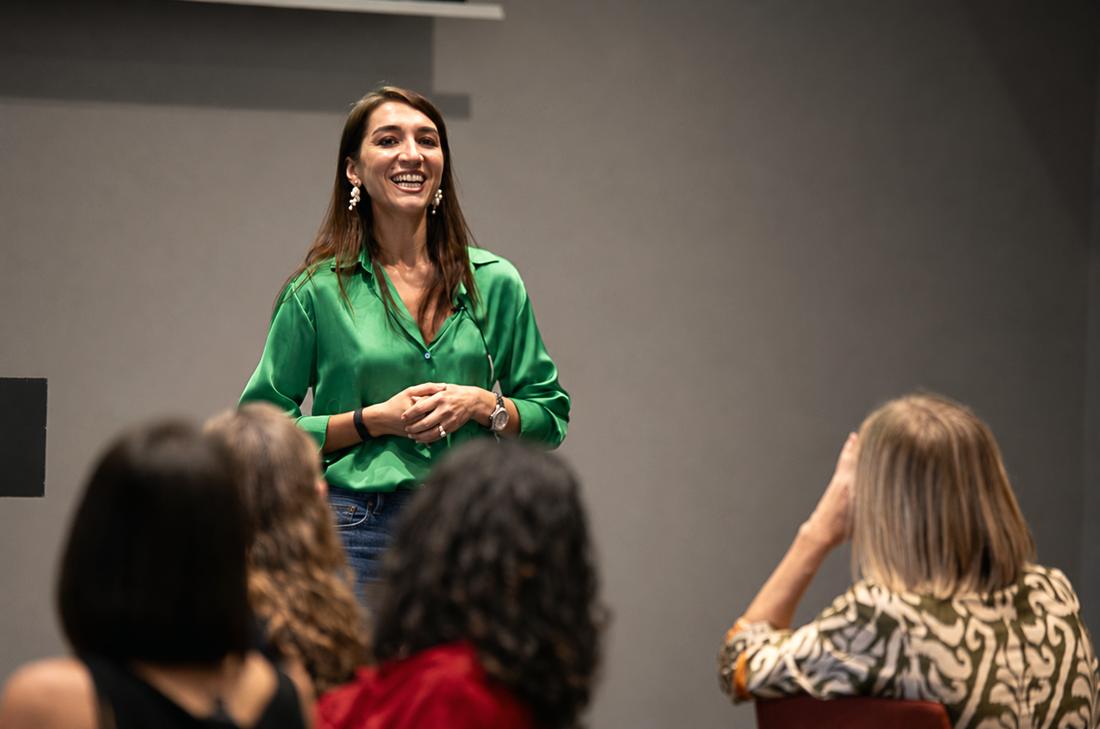 Irina smiling at her audience in a green satin shirt