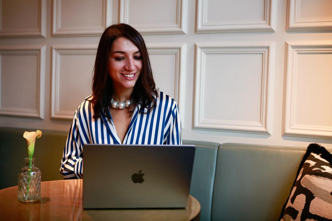 Irina smiling as she types on her laptop